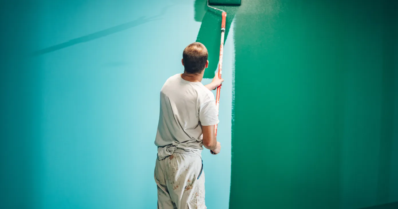 Rouleau appliquant de la peinture verte sur un mur