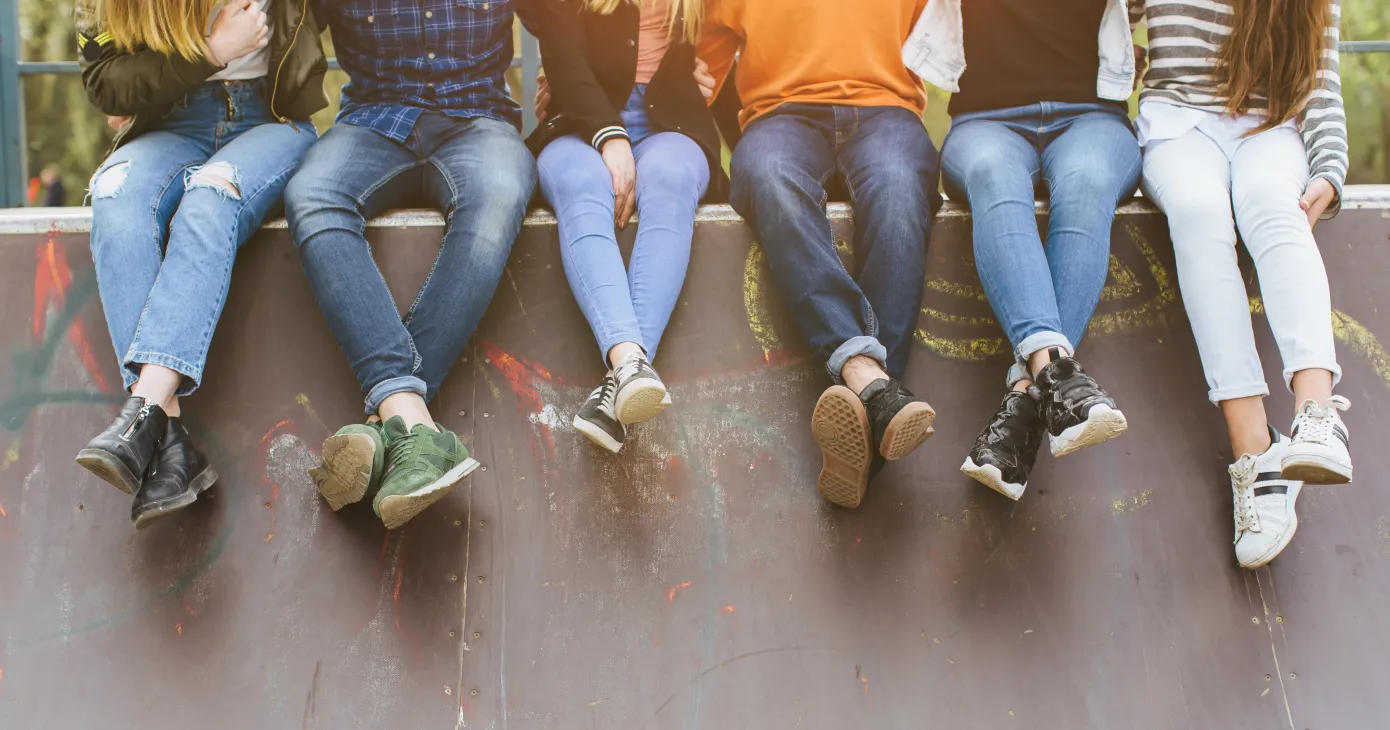 Summer holidays and teenage concept - group of smiling teenagers with skateboard hanging out outside.