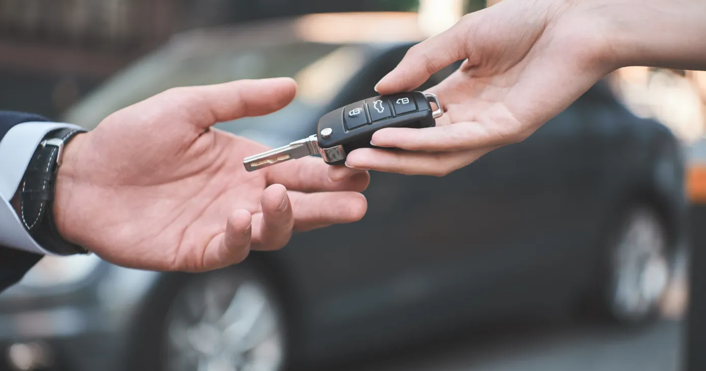 Car dealership.Young man receiving car key from saleswoman.