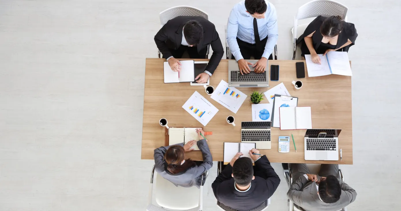Réunion de travail vue de dessus, documents étalés sur la table