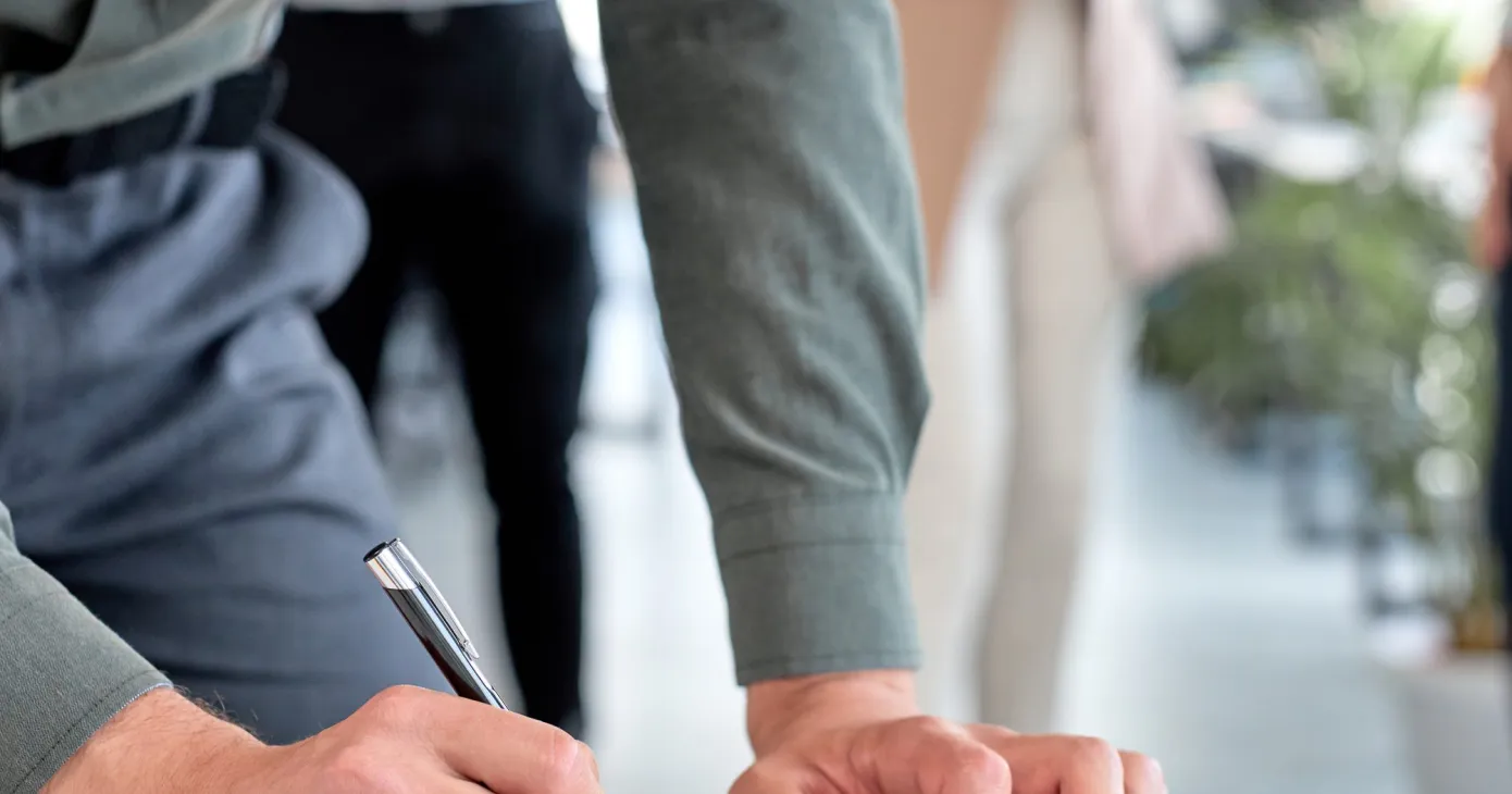 Personne signant un document posé sur un porte-bloc