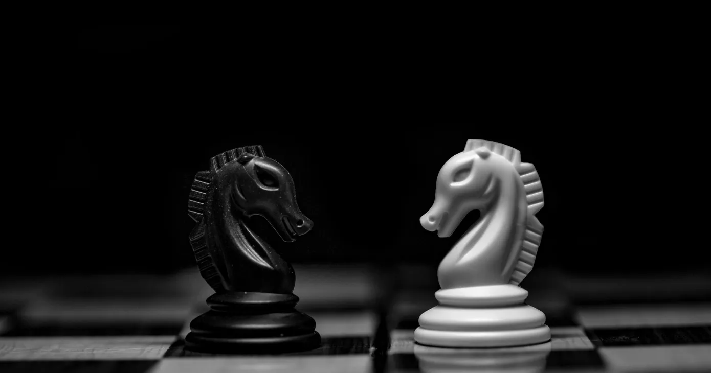 Deux cavaliers d'échecs, un noir et un blanc, face à face