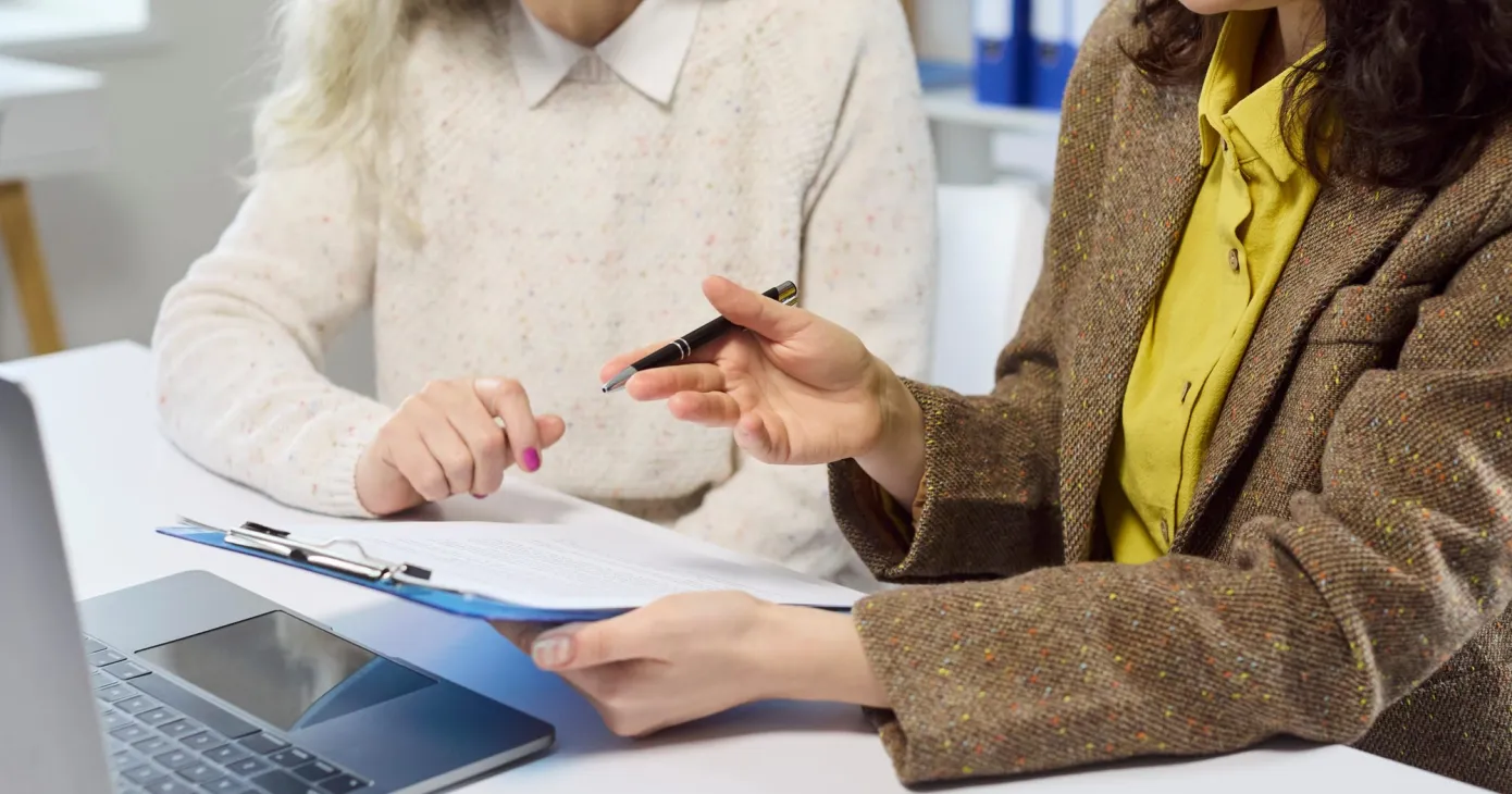 Deux personnes face à un document et un ordinateur portable