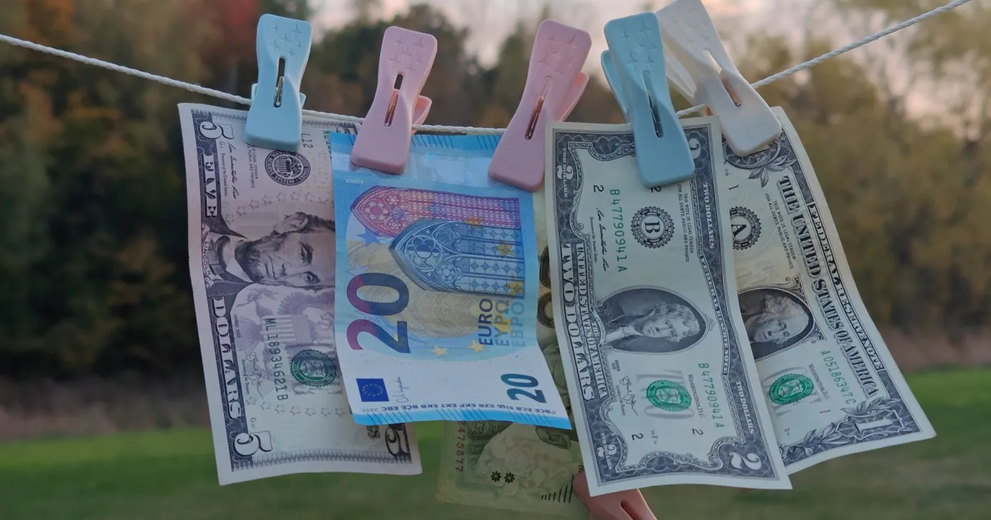 Billets en euros et en dollars suspendus à une corde à linge
