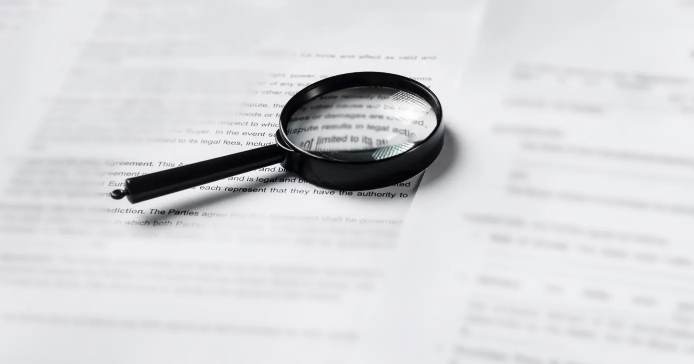 Loupe posée sur une pile de documents papier